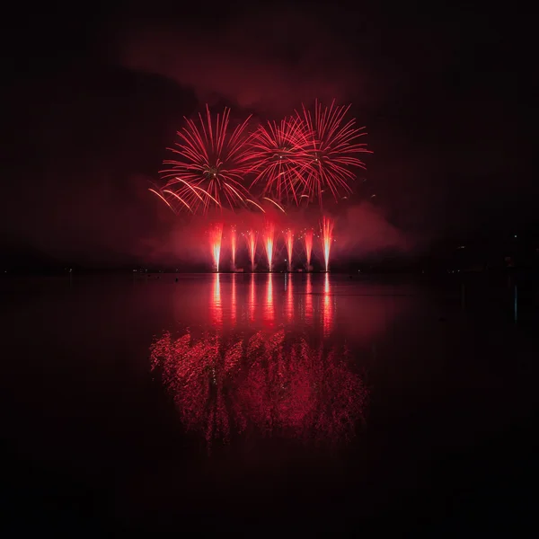 Fuegos artificiales coloridos con reflexión sobre el lago . — Foto de Stock