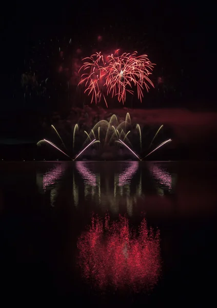 Fuegos artificiales coloridos con reflexión sobre el lago . — Foto de Stock