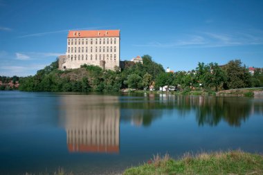 Avrupa 'daki Çek Cumhuriyeti, Moravya' daki Plumlov kalesi. Kale kayalık bir tepenin üzerine inşa edildi. Kale göletin yüzeyine yansıyor. ND filtresi ile uzun pozlama. 