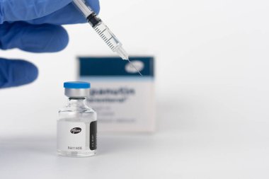 Brnenec, Çek Cumhuriyeti - 12 Aralık 2020: Eldiven, şırınga ve şişe Epanutin 'in parmakları. Epanutin, Pfizer tarafından üretilir. İlaç şirketi Pfizer da Covid-19 üzerinde bir aşı geliştirdi..