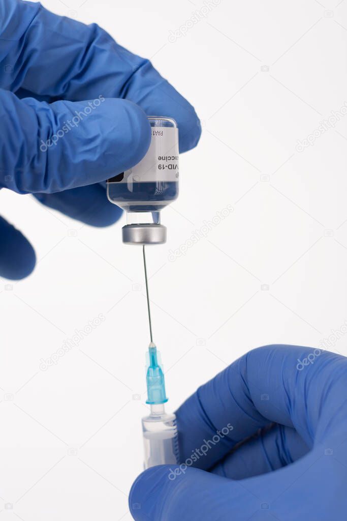 Close up human fingers in gloves, holding covid-19 vaccine vial  and syringe with needle. Medical concept. 