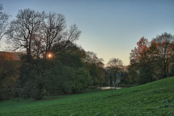 Podzimní park a malé jezero při západu slunce — Stock fotografie