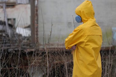 Adam ile koruyucu maske ve koruyucu giysiler araştırıyor tehlike alanı