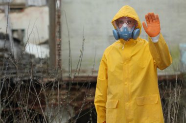 Adam ile koruyucu maske ve koruyucu giysiler araştırıyor tehlike alanı