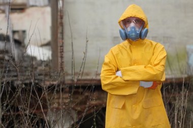 Adam ile koruyucu maske ve koruyucu giysiler araştırıyor tehlike alanı