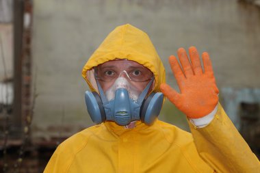 Adam ile koruyucu maske ve koruyucu giysiler araştırıyor tehlike alanı
