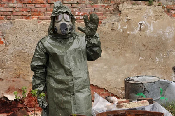 Homme avec masque à gaz et vêtements militaires verts explore oiseau mort après une catastrophe chimique . — Photo