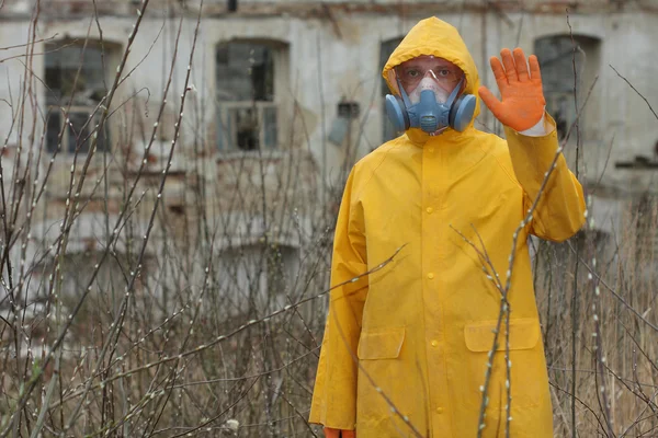 Людина з захисною маскою та захисним одягом досліджує небезпечну зону — стокове фото