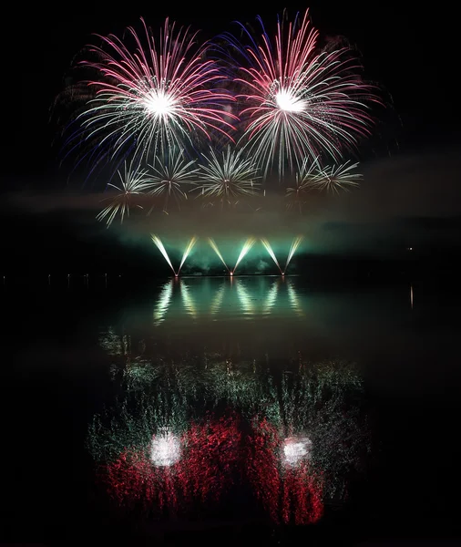 Farbenfrohes Feuerwerk mit Spiegelung am See. — Stockfoto