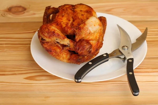 Frango grelhado inteiro com tesouras para aves de capoeira em placa branca — Fotografia de Stock