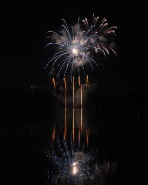 Göl üzerinde yansıması ile renkli havai fişek.