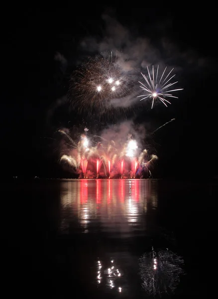 Farbenfrohes Feuerwerk mit Spiegelung am See. — Stockfoto