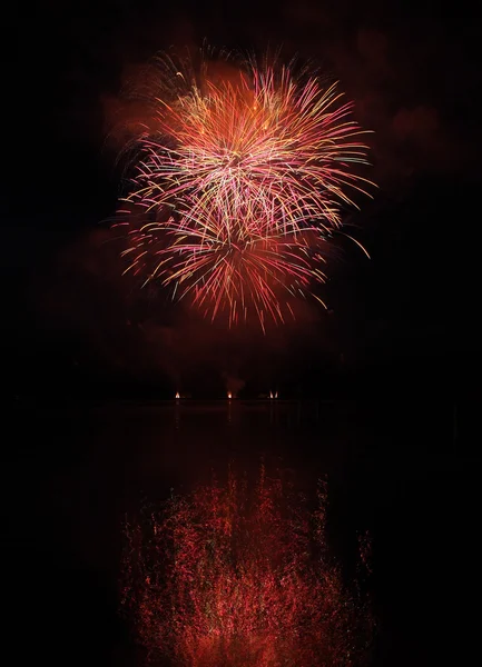 Farbenfrohes Feuerwerk mit Spiegelung am See. — Stockfoto