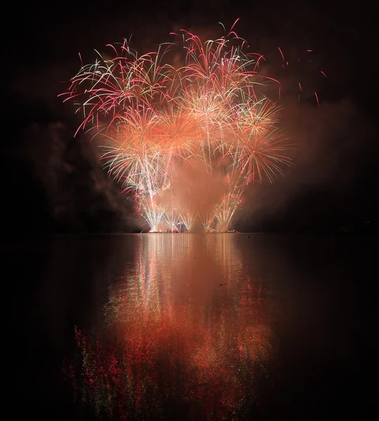 Farbenfrohes Feuerwerk mit Spiegelung am See. — Stockfoto