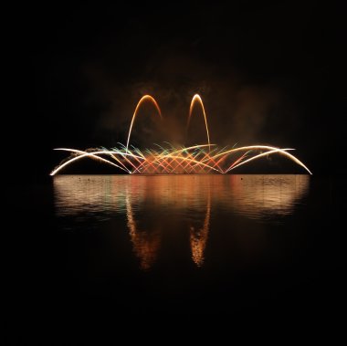 Göl üzerinde yansıması ile renkli havai fişek.