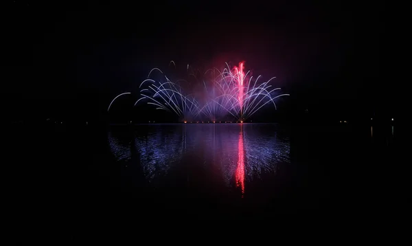 Fuegos artificiales coloridos con reflexión sobre el lago . — Foto de Stock