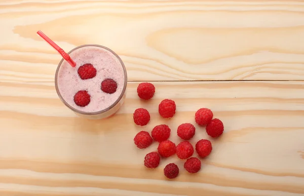 Smoothie dari raspberry dalam gelas dan raspberry di kayu — Stok Foto