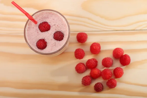 Smoothie dari raspberry dalam gelas dan raspberry di kayu — Stok Foto