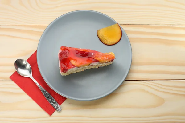 Truskawkowym i brzoskwiniowym ciasto z żelatyny na szare płytki na drewniane t — Zdjęcie stockowe