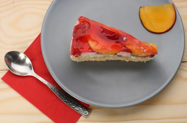 Gâteau aux fraises et pêches avec gélatine sur plaque grise sur t en bois — Photo