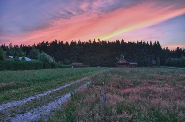 Çayır, arka plan ağaç günlük kabin ve renkli gökyüzü — Stok fotoğraf