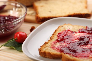 Tatlı ekmek kuru üzüm ve badem, tereyağı ve kiraz reçeli 