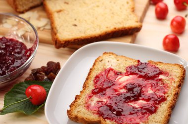 Tatlı ekmek kuru üzüm ve badem, tereyağı ve kiraz reçeli 