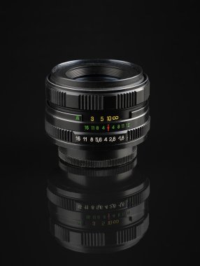 old manual lens with reflection on black acrylic sheet