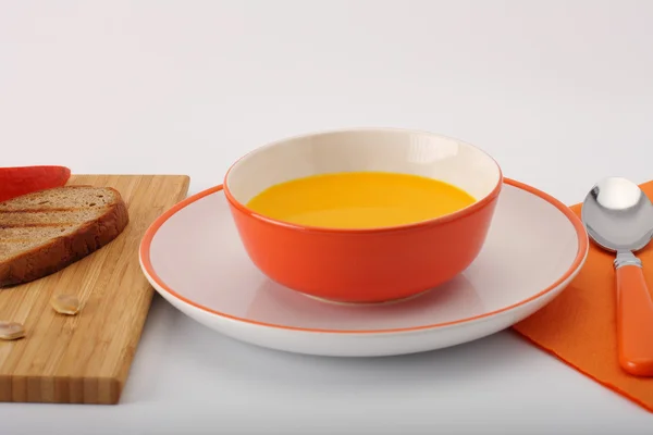 Bowl of pumpkin hokkaido soup with bread  on white — Stock Photo, Image