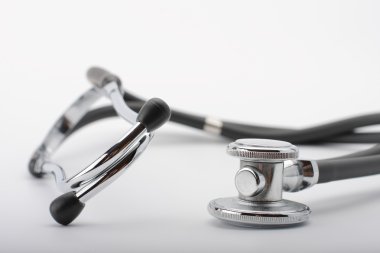 Beyaz arka plan üzerinde siyah stetoskop görünümü kapatın.
