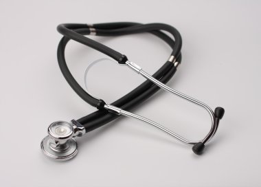 Beyaz arka plan üzerinde siyah stetoskop görünümü kapatın.