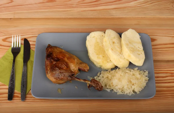 Pato assado, repolho e bolinhos na placa cinzenta — Fotografia de Stock