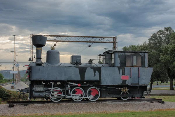 Old steam locomotive at train station on cloudy day — Stock Photo, Image