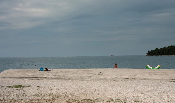 Playa de la ciudad en día nublado en Rovinj en Croacia — Foto de Stock