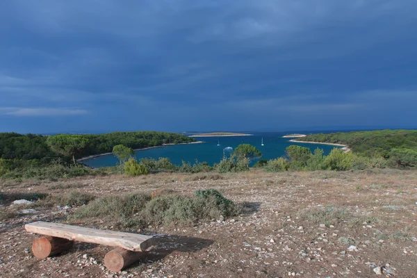 Ξύλινο πάγκο, σε φόντο του κόλπου Portic στο Kamenjak — Φωτογραφία Αρχείου