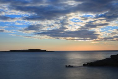 Bulutlar deniz seviyesinden arkasında güneşte günbatımı zamanı