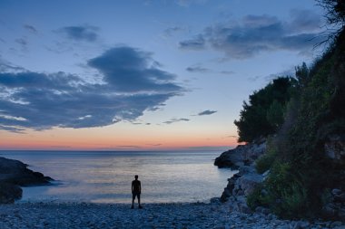 Deniz güneş battıktan sonra ayakta adam silüeti