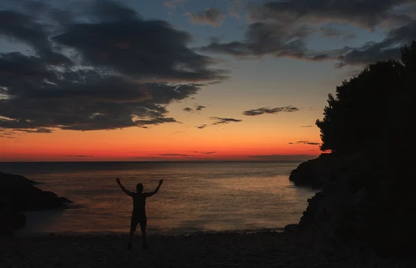 Silhouette of praying man after sea sunset — Stock Photo, Image