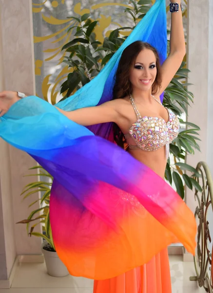 Mooie brunette, buikdanseres met rainbow sjaal in het Arabisch harem-interieur — Stockfoto