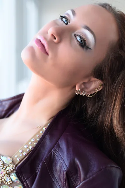 Glamorous young brunette woman in purple leather jacket and sparkly bra with beautiful makeup — Stock Photo, Image