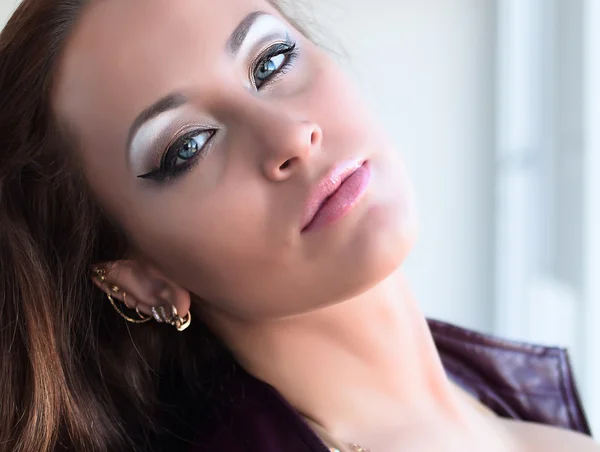 Okouzlující mladá bruneta žena v fialovou koženou bundu a jiskřivý podprsenku s krásným make-upem, při pohledu na fotoaparát — Stock fotografie