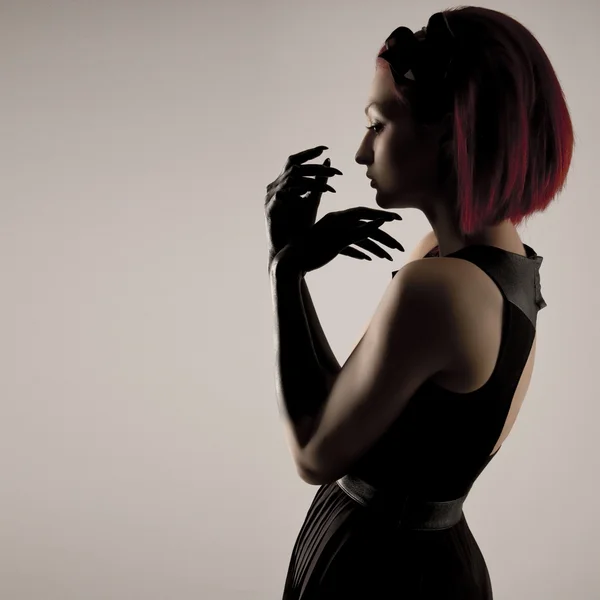 Mooie elegante vrouw met rood haar en zwarte handen — Stockfoto