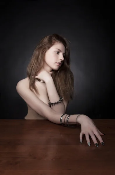 Studio shot. Portrait of fashionable model with long curly ginger red hair and natural make-up posing behind wooden table. Perfect skin, virgin lips. Body lines concept. — Stock Photo, Image