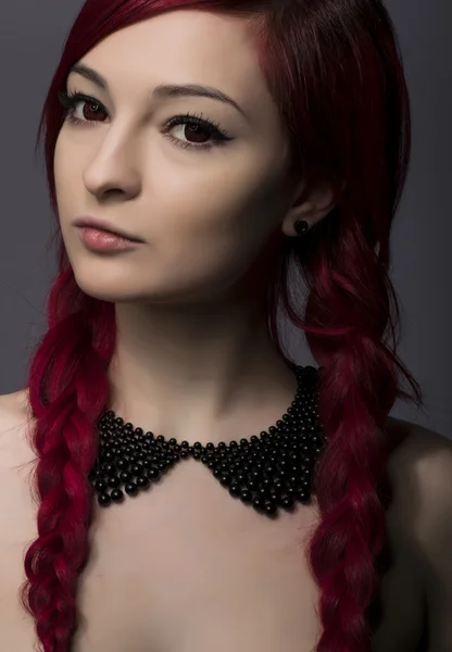 Hermosa mujer con pelo leído y cuello posando sobre fondo gris —  Fotos de Stock