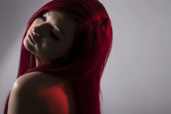 Beautiful red haired woman posing over grey background — Stock Photo, Image