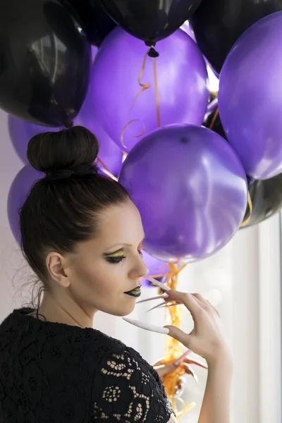 Beautiful one-eyed brunette with long nails and balloons — Stock Photo, Image