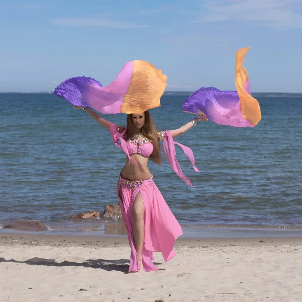 Dançarina do ventre em traje colorido na praia com fãs — Fotografia de Stock