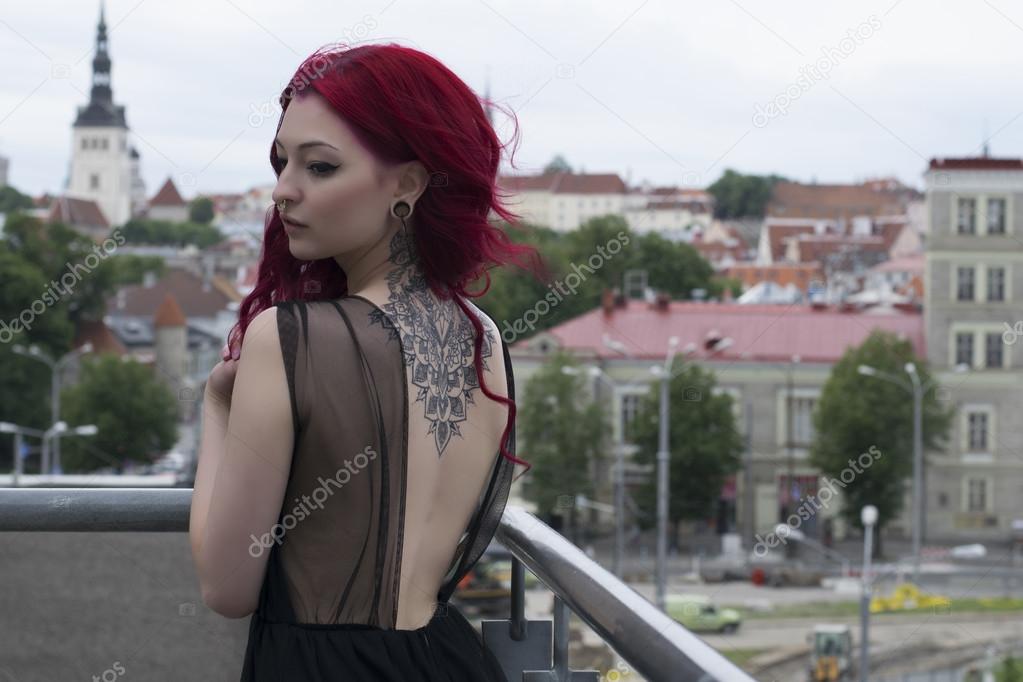Redhead fashion model on parking balcony with city view background