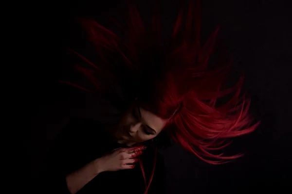 Donkere portret van een mooi meisje met de ontwikkeling lang rood haar en vingers in bloed — Stockfoto