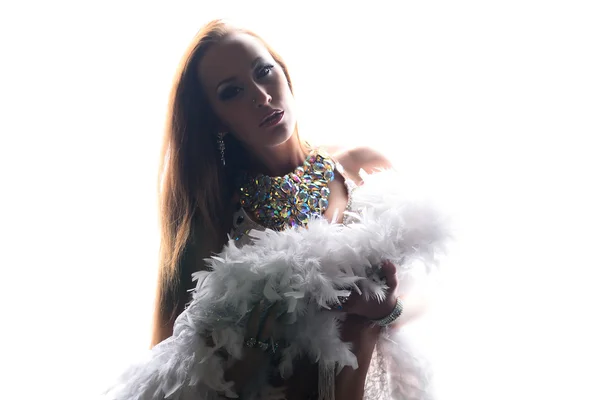 Beautiful woman in white stage costume with boa and bling-bling necklace over white light — Stock Photo, Image